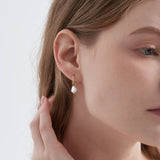 STMG Pearl Dangle Hoops in gold on ear